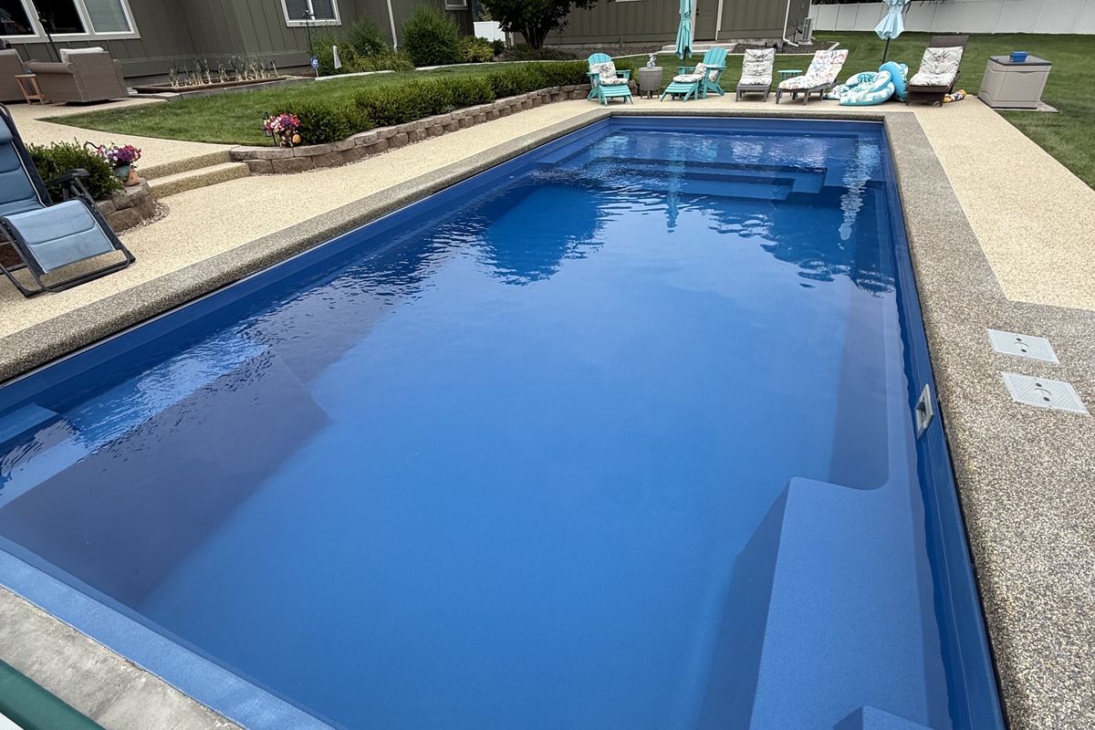 Rectangular backyard pool with lounge chairs