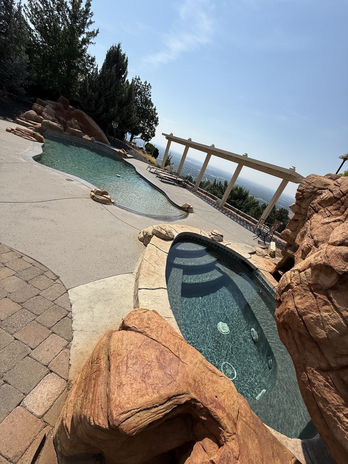 Hillside pool and spa with a valley view